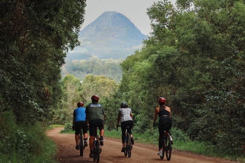 Noosa gravel bike riders on gravel road with mt Cooroora in the noosa hinterland background